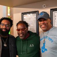 Three event attendees standing together and smiling for camera